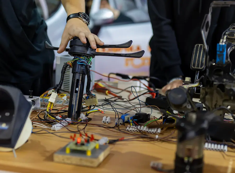 Three students interact with circuit boards using a DMM; one student takes notes while the other two probe and inspect the board.