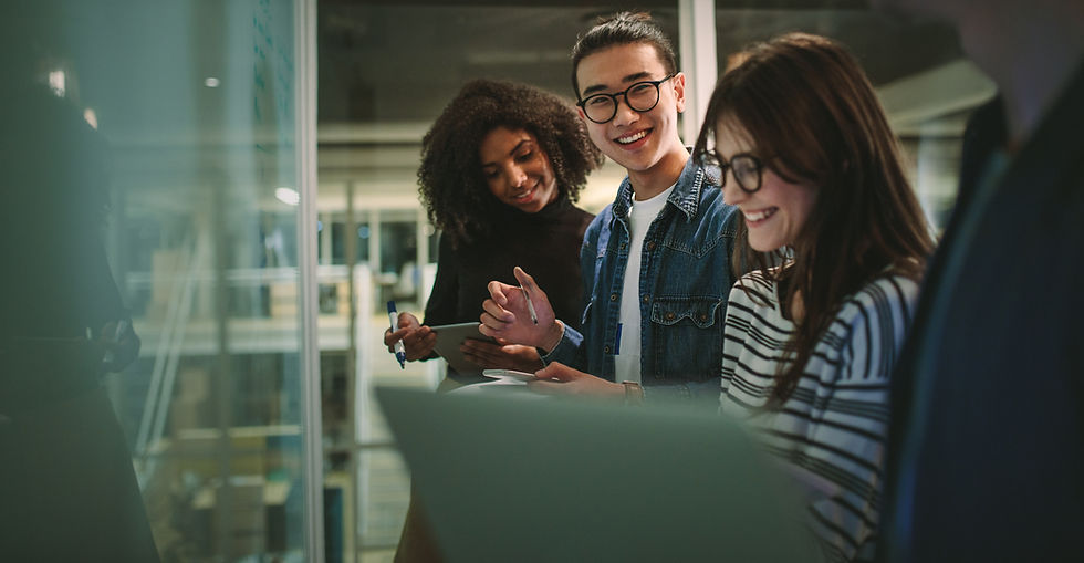 Four Undergraduate Students smiling and working on a board